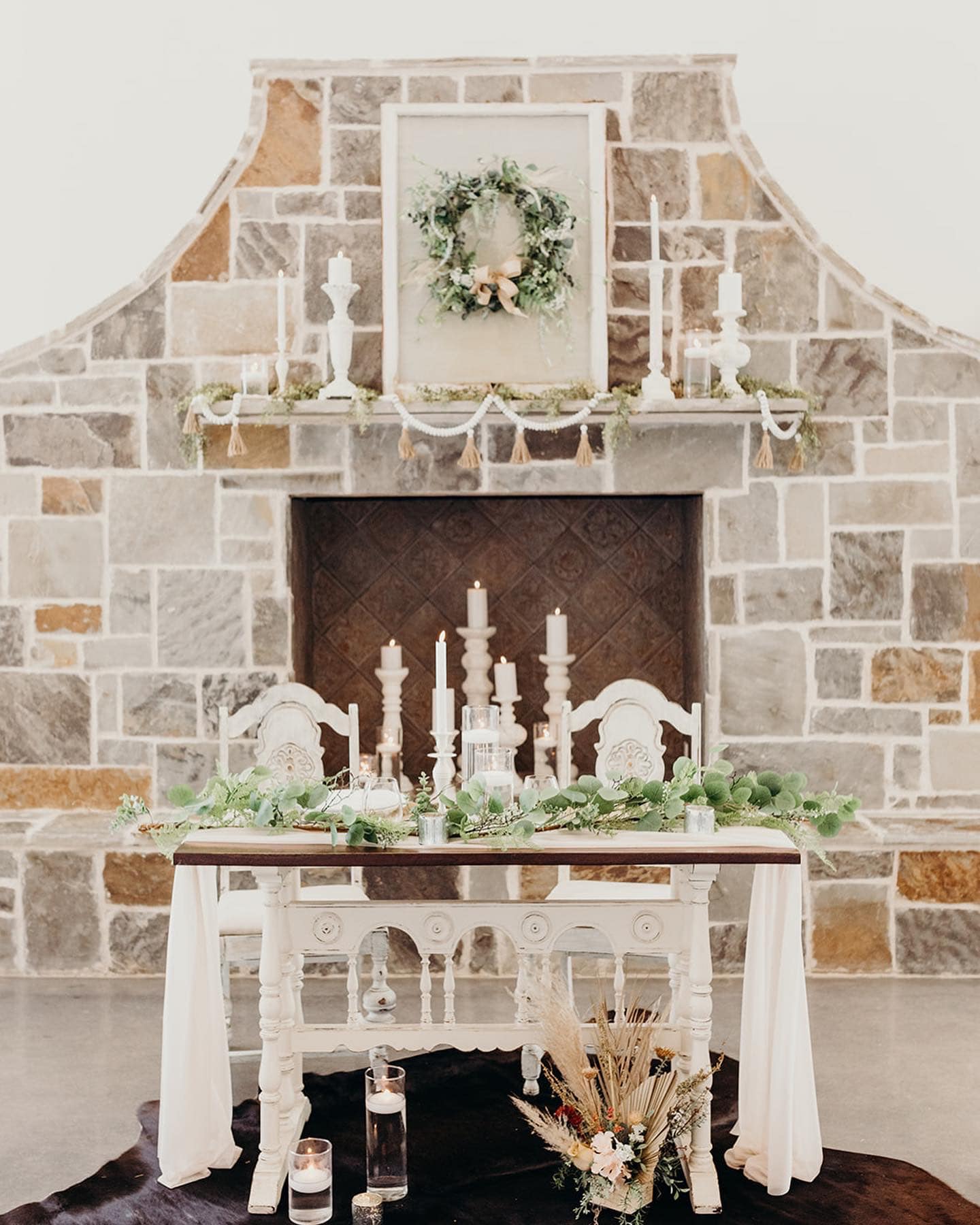 rustic bride and groom's table in front of fireplace at wedding reception