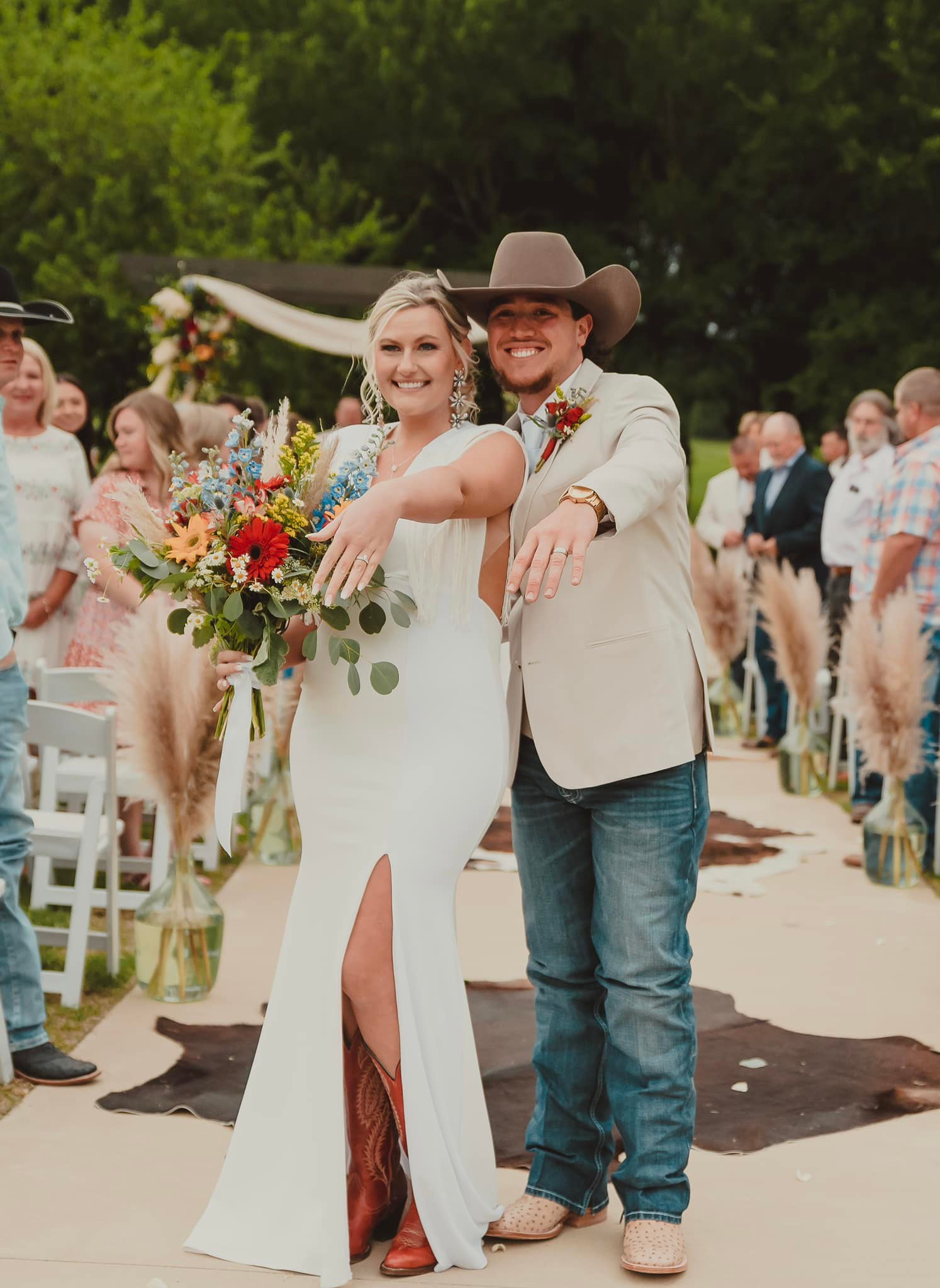 bride and groom showing off wedding rings