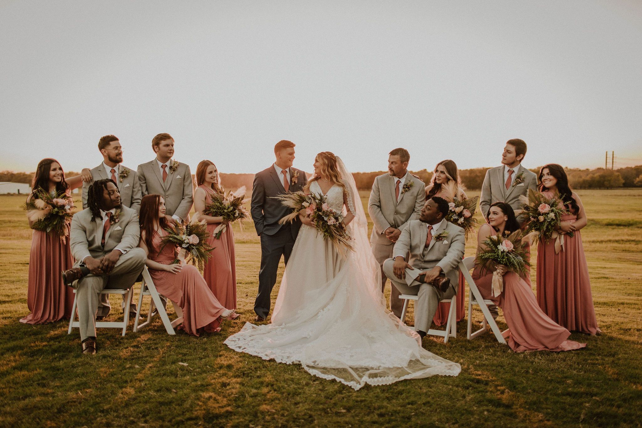 bride and groom with wedding party at sunset